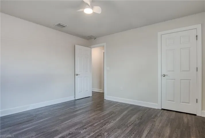 Unfurnished bedroom featuring ceiling fan and dark hardwood / wood-style flooring