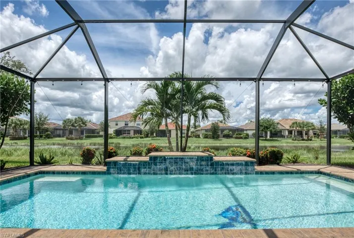 View of pool with glass enclosure and pool water feature
