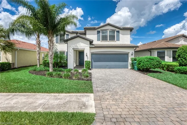 View of front of home with a garage and a front lawn
