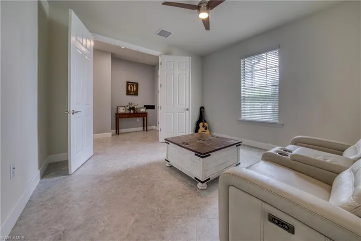 Living room featuring vaulted ceiling, light tile patterned floors, and ceiling fan