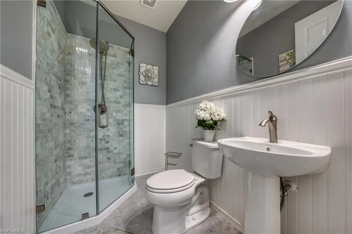 Bathroom featuring toilet and a shower with shower door