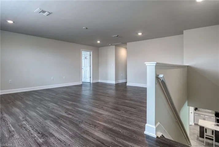 Unfurnished room with dark hardwood / wood-style flooring