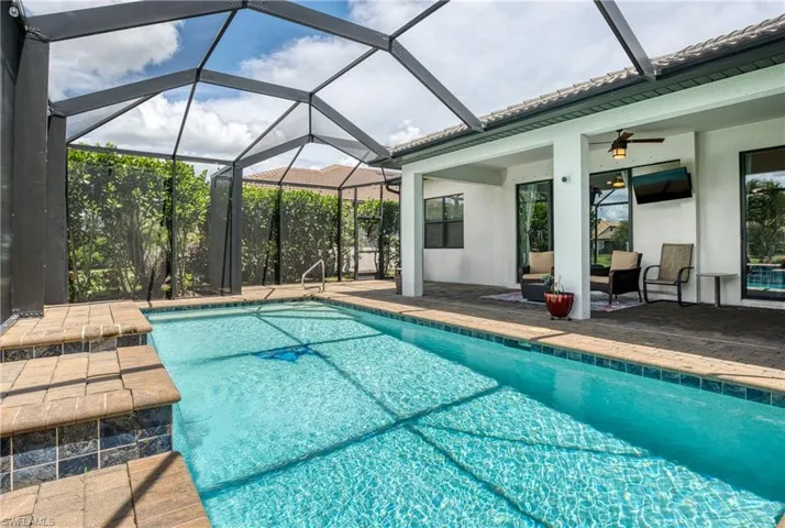 View of pool featuring a patio area, ceiling fan, and a lanai