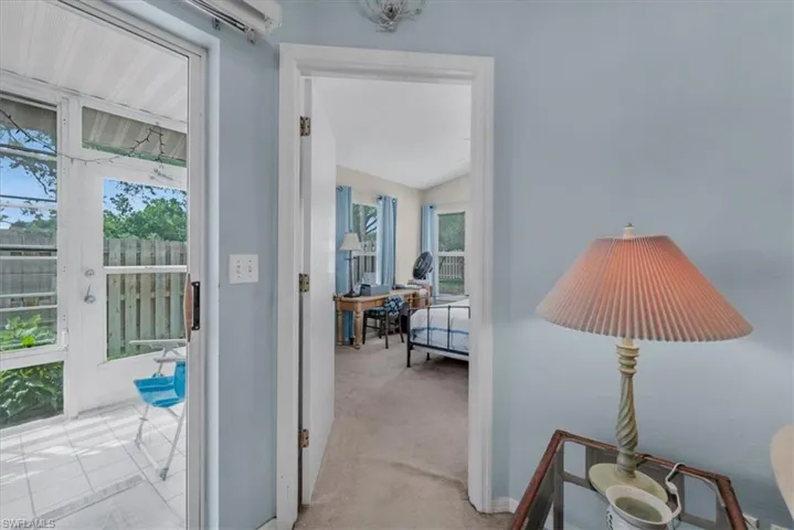 Corridor with light colored carpet and baseboards