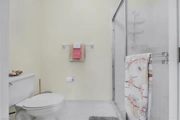 Bathroom with toilet and a stall shower