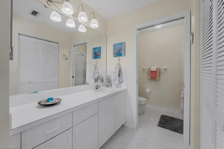 Bathroom featuring a closet, vanity, and light marble finish flooring