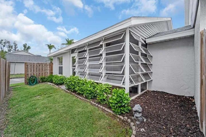 Rear view of house featuring a sunroom and stucco siding