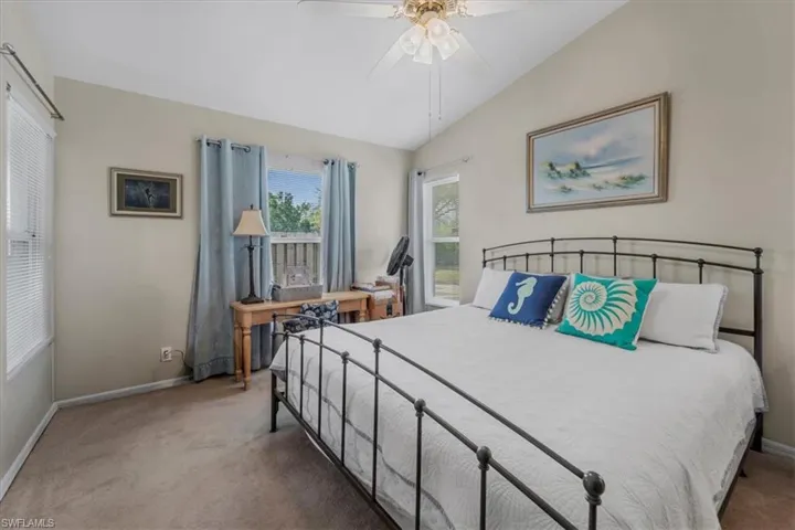 Bedroom with lofted ceiling, carpet floors, and ceiling fan