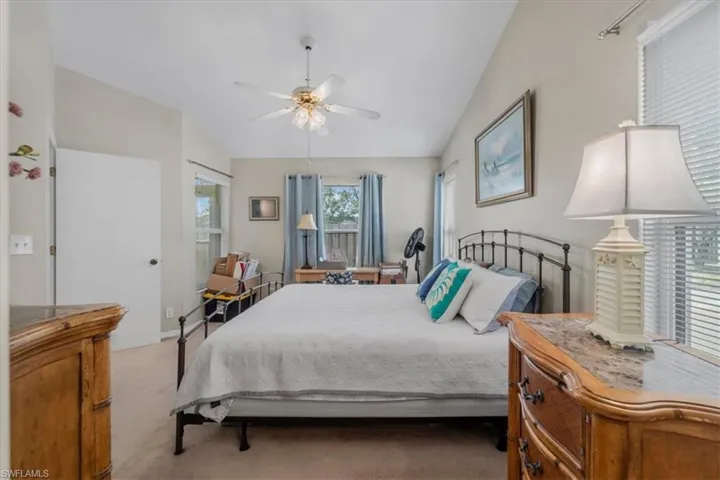 Carpeted bedroom with lofted ceiling and ceiling fan