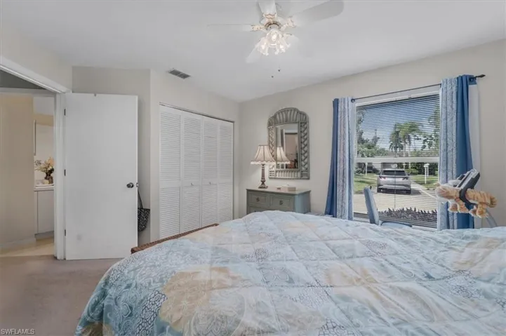 Carpeted bedroom featuring a closet and ceiling fan