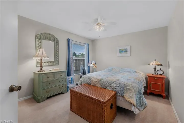 Bedroom with a ceiling fan and light carpet