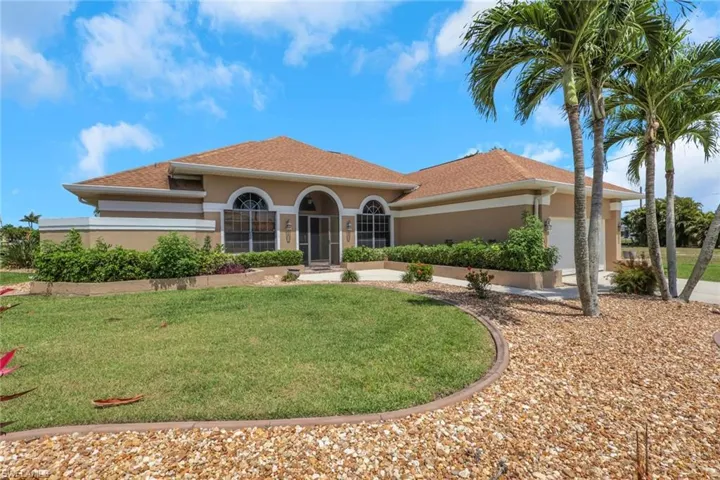 Stucco exterior with a hip roof, featuring arched windows and an arched screened entry