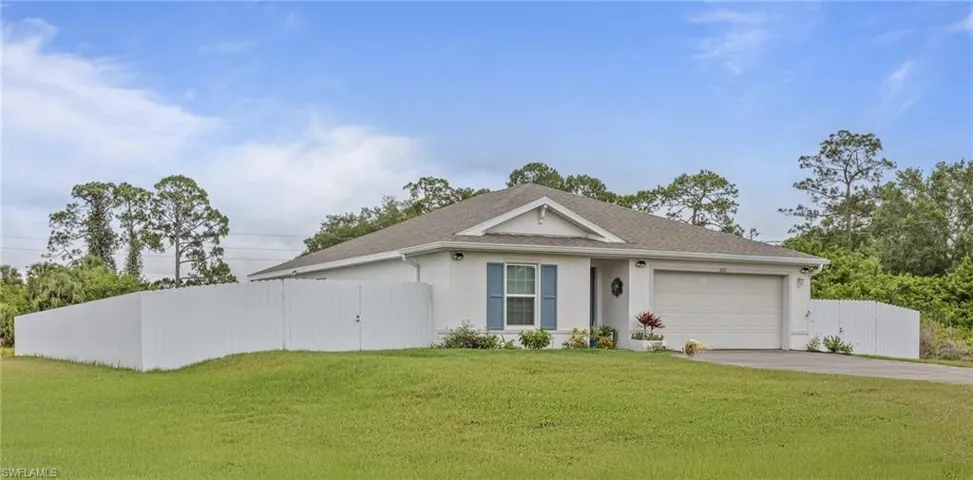 Single story home with concrete driveway, a garage, stucco siding, and a gate