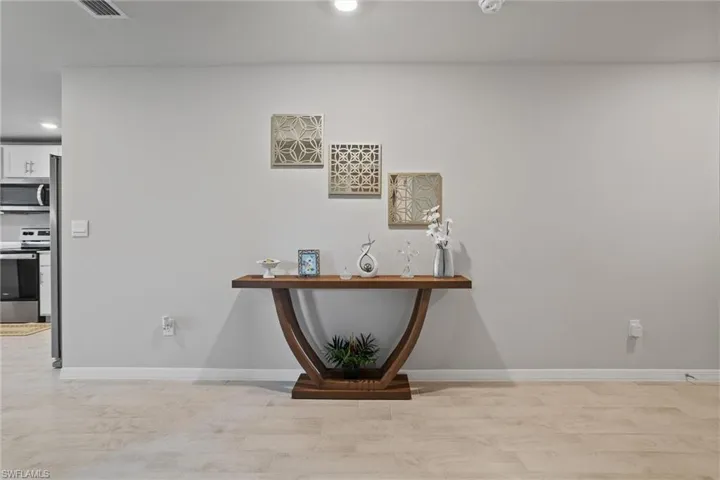 Detailed view of appliances with stainless steel finishes, recessed lighting, wood finished floors, and baseboards