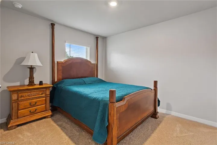 Bedroom featuring light carpet and baseboards