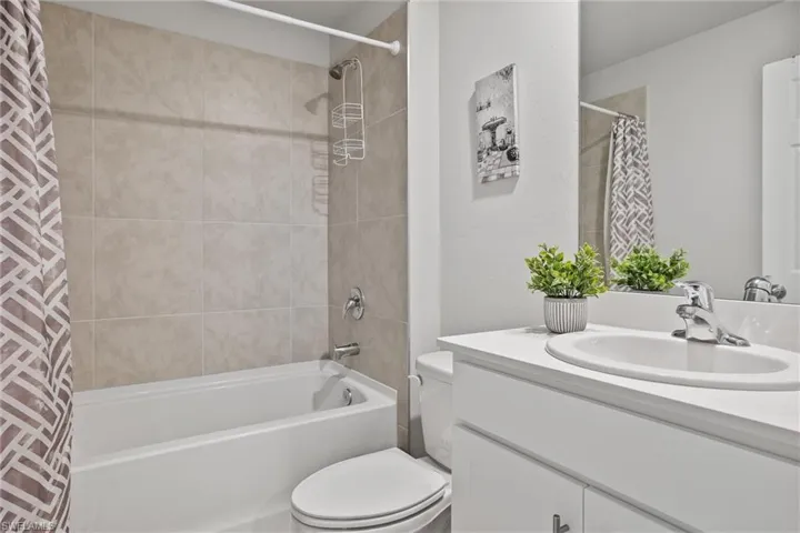 Full bath featuring shower / bath combo with shower curtain, vanity, and toilet