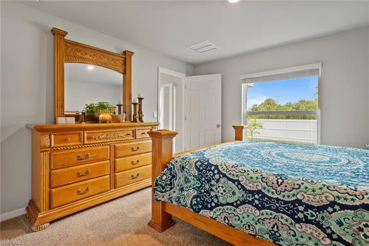 Bedroom with light colored carpet and baseboards