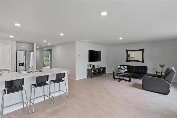 Living area with recessed lighting, light wood finished floors, and baseboards