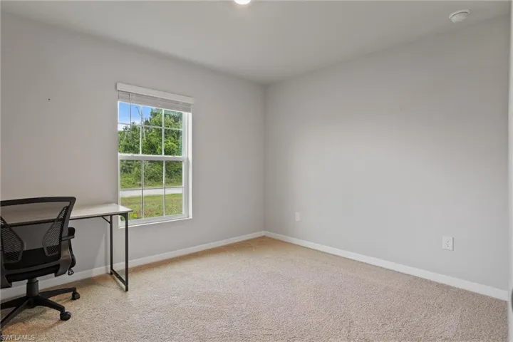 Unfurnished office with carpet flooring and baseboards