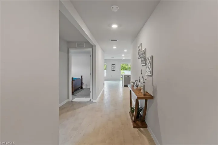 Hall featuring light wood-style flooring, recessed lighting, and baseboards