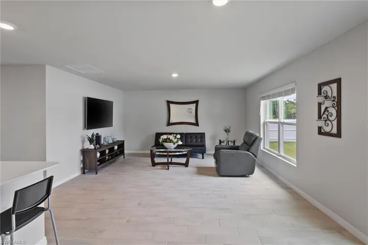 Living room featuring light wood-style floors, recessed lighting, and baseboards