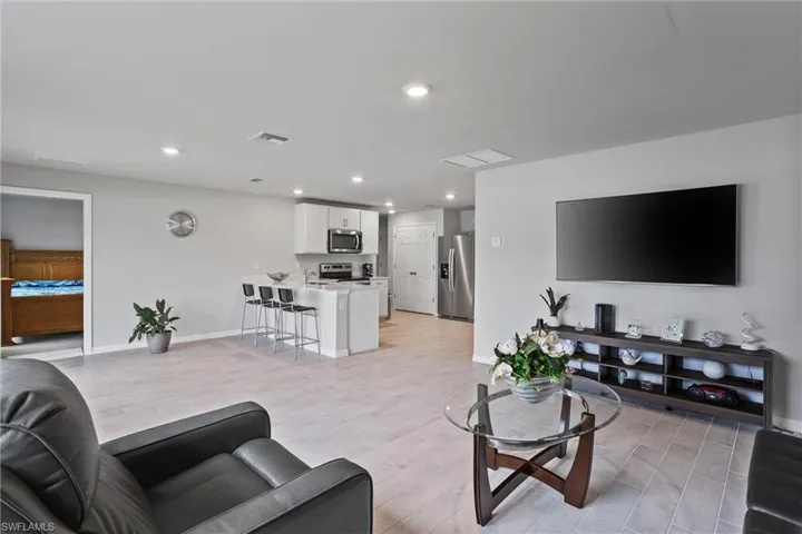 Living room with baseboards, recessed lighting, and light wood finished floors
