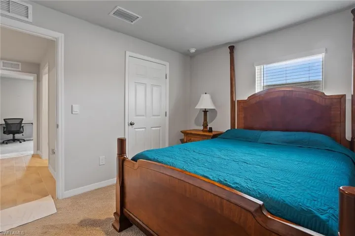 Bedroom featuring light carpet and baseboards