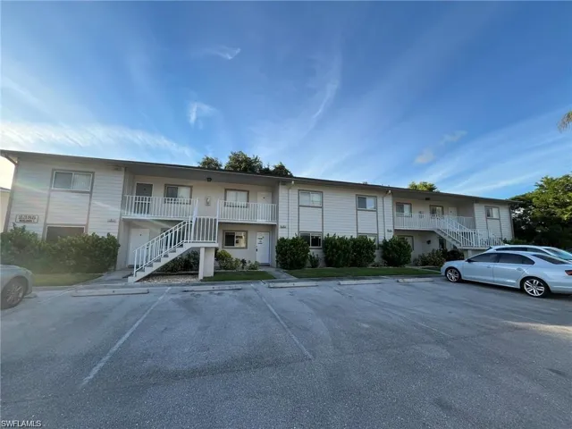 View of front of home featuring stairway and uncovered parking