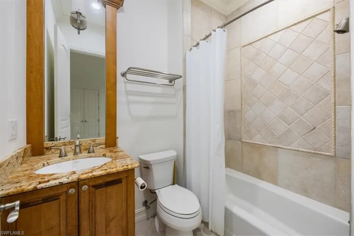 Guest bathroom with granite counter, toilet and shower/tub combo.