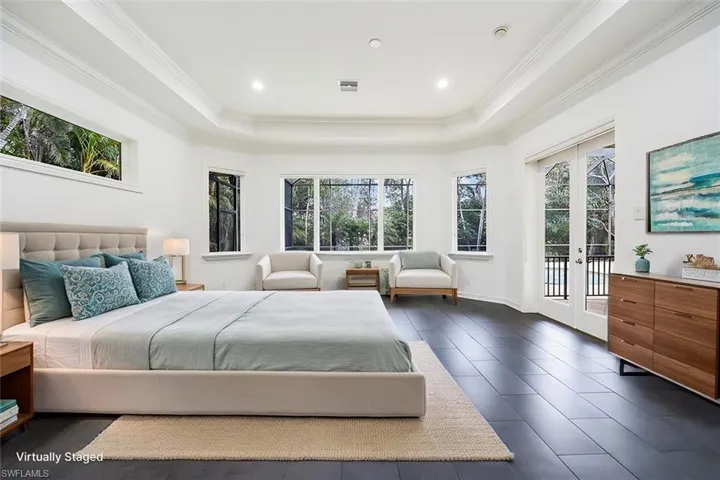 Virtually Staged - Large primary bedroom with tile floors, windows/sliders for natural light and access to the pool/spa/lanai.