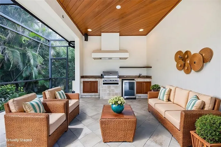 Virtually Staged - Outdoor kitchen with grill & vent hood, beverage cooler, sink and storage.