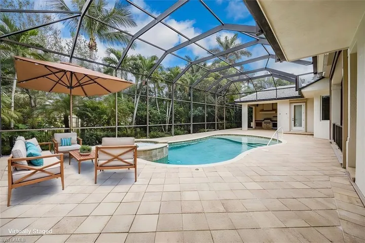 Virtually Staged - Enclosed lanai with pool, spa, covered area (to the far right) and outdoor kitchen.