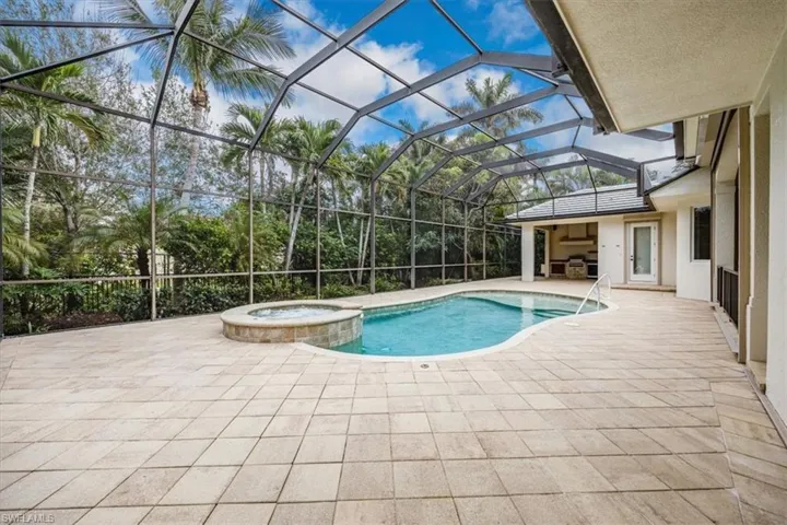 Enclosed lanai with pool, spa, covered area (to the far right) and outdoor kitchen.