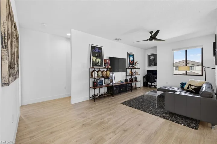 Living room with light wood finished floors and a ceiling fan