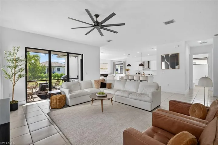 Living room with a ceiling fan and light tile patterned floors