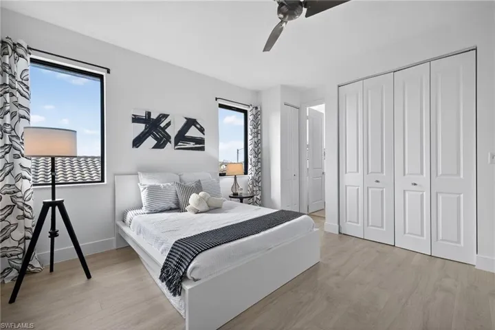 Bedroom featuring light wood-style flooring, a ceiling fan, and a closet