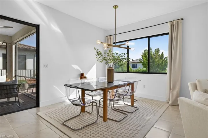 Dining room with healthy amount of natural light, light tile patterned floors, and hanging lights