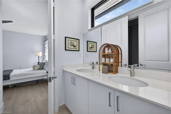 Bathroom featuring ensuite bathroom, double vanity, and light wood-type flooring