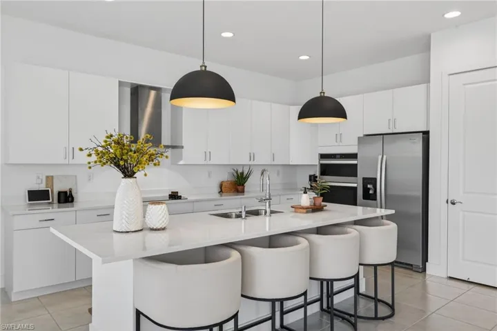 Kitchen featuring stainless steel appliances, white cabinets, and light tile patterned floors