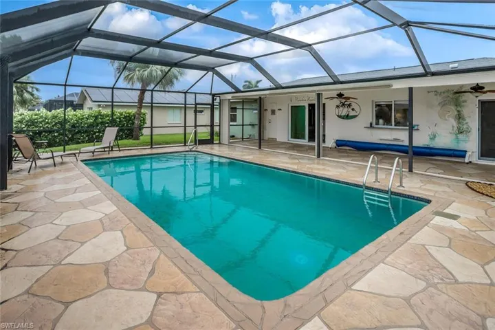View of pool with a lanai, a patio area, and ceiling fan. Pool and deck have been resurfaced.