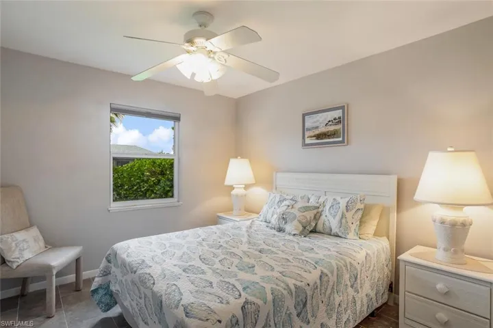 Third bedroom featuring tile patterned floors and ceiling fan