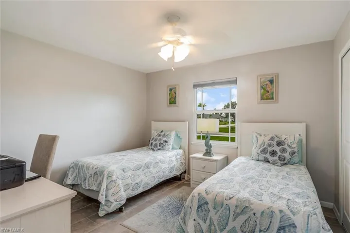 Tiled guest bedroom with ceiling fan