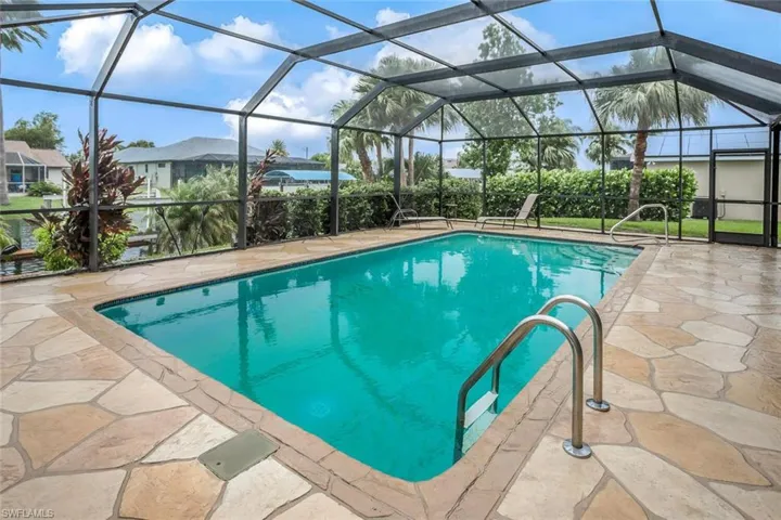 Another pool view overlooking landscaped area, canal, and Western exposure.