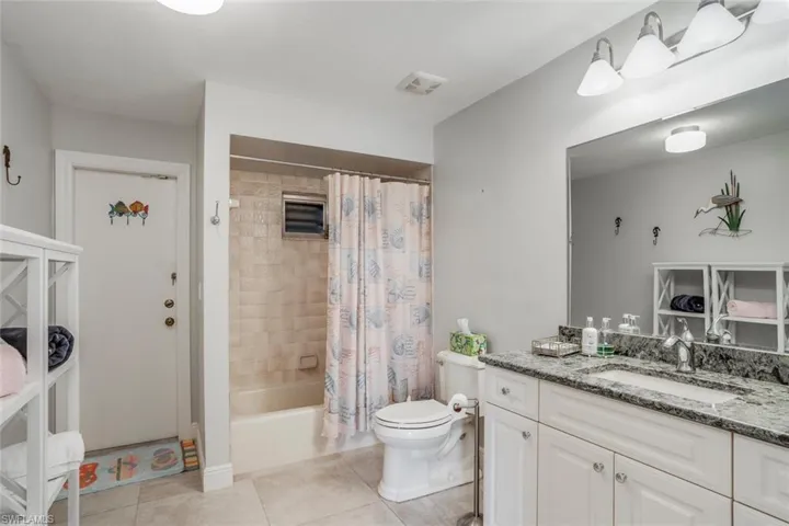 Spacious upgraded second/guest bath with tile/shower combo and access to the pool.