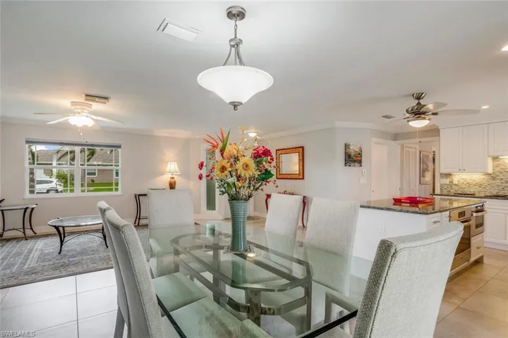 Dining area featuring light tile patterned flooring, ceiling fan, and crown molding