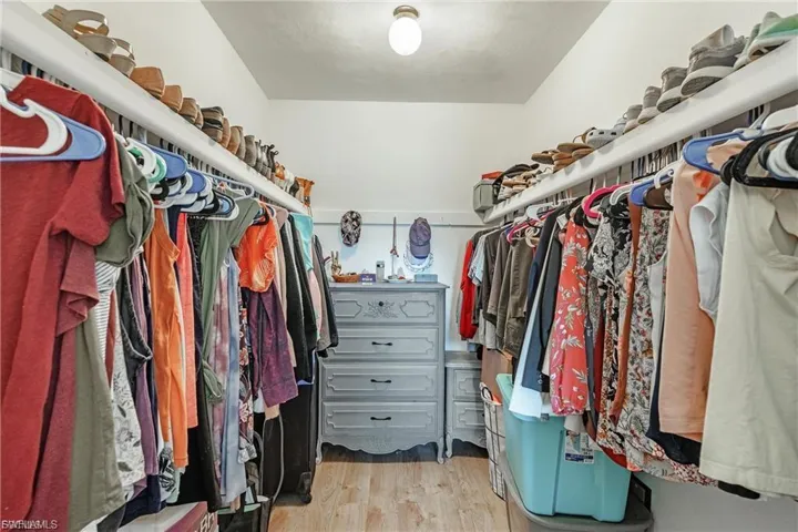 Spacious closet featuring light wood-style flooring