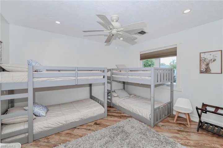 Bedroom featuring wood plank tile flooring and ceiling fan