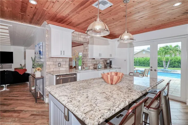 Kitchen featuring decorative light fixtures, a kitchen island, decorative backsplash, wooden ceiling, and wood plank tile flooring