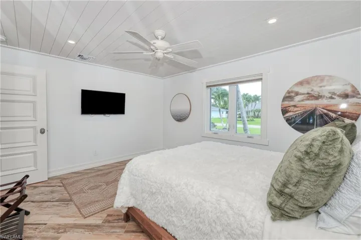 Bedroom featuring ornamental molding, ceiling fan, wood plank tile floors and a wood ceiling