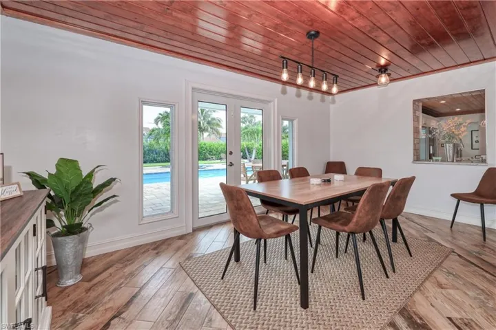 Dining room featuring wooden ceiling, wood plank tile floors, french doors, and track lighting